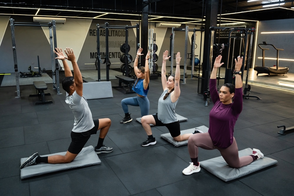Personal trainer mittaa asiakkaan kehonkoostumusta tarkkuusmittarilla salilla